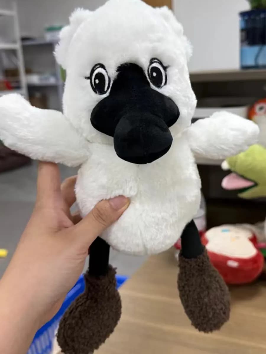 White fluffy animal plush toy with a moulded black nose