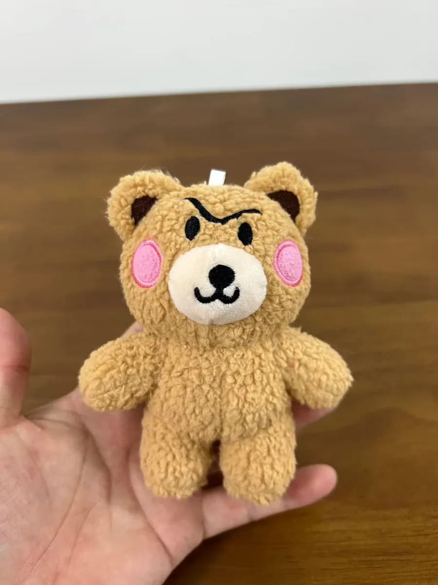 Classic teddy bear in soft brown plush with a knitted hat