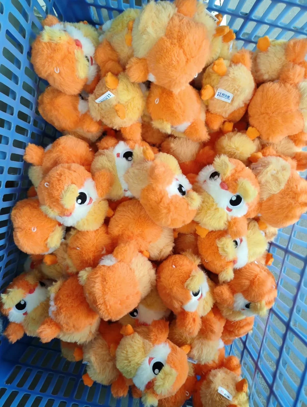 Bulk run of orange plush toys in a production crate