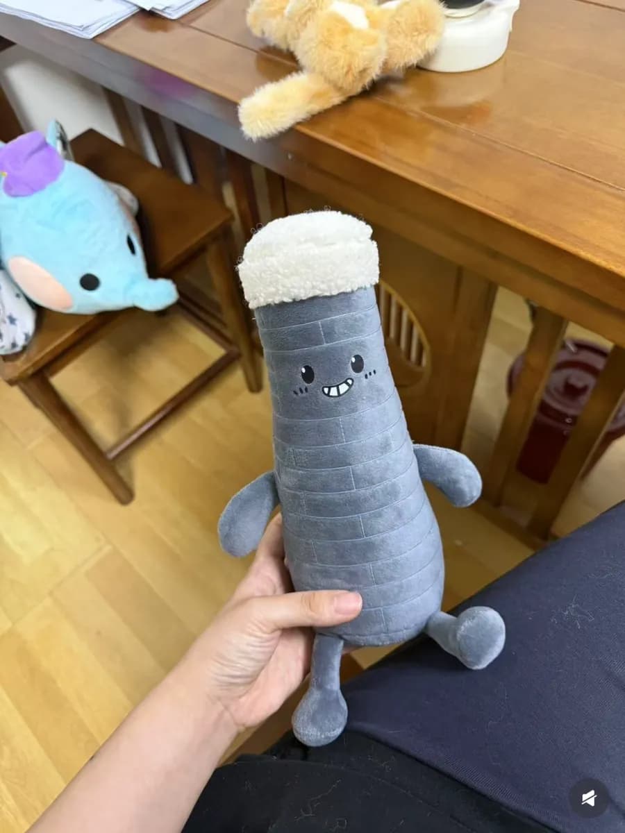Bottle-shaped plush toy with a printed label