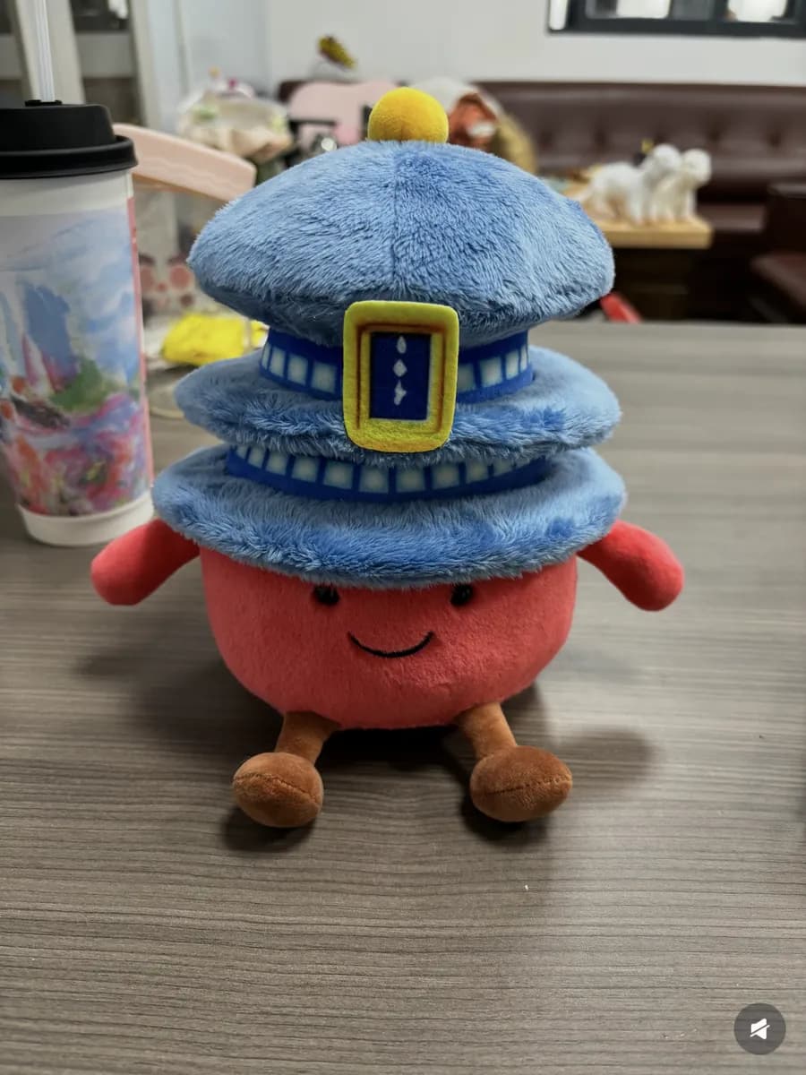 Character plush toy wearing a stacked burger hat