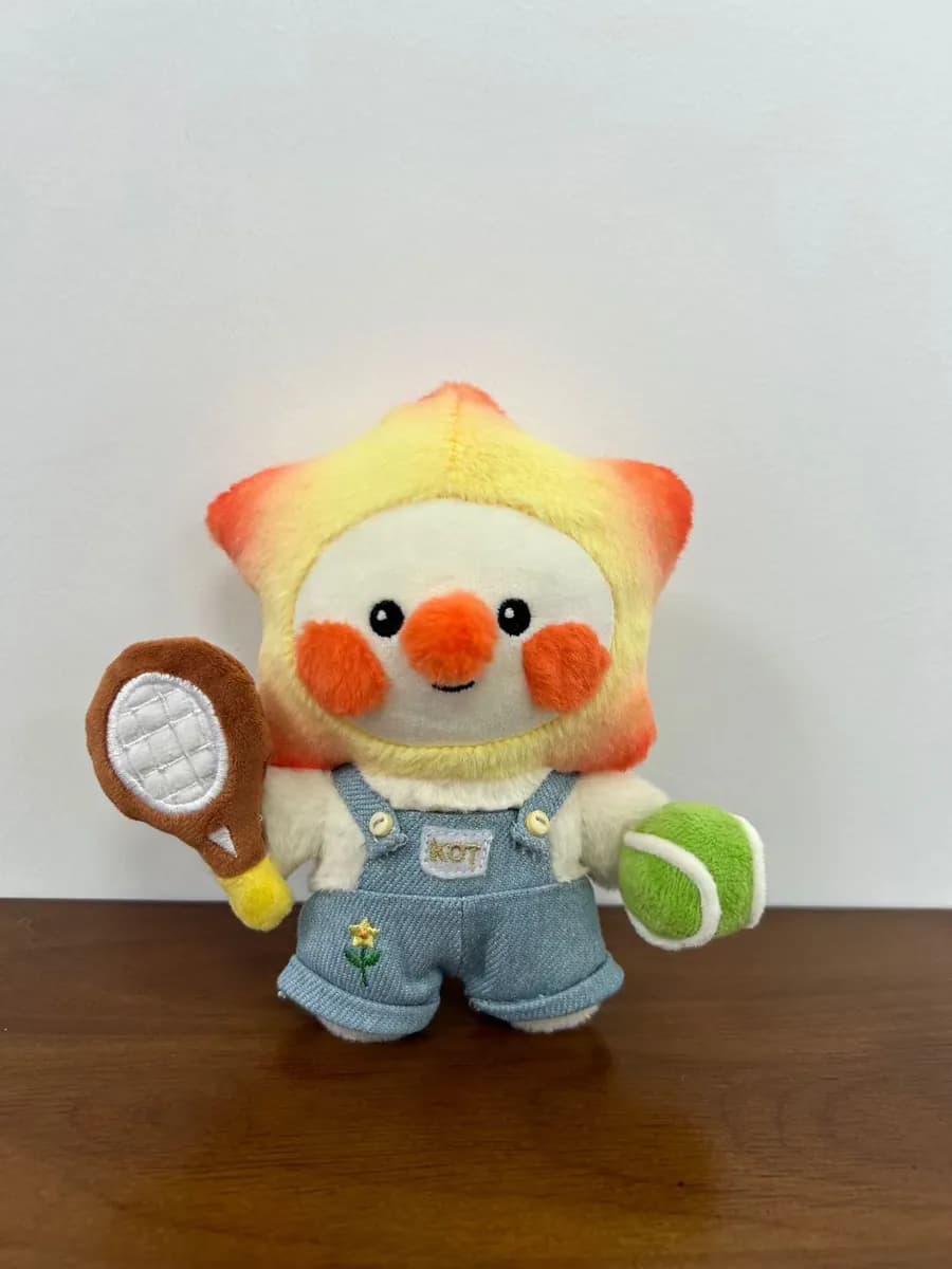 Bird mascot plush holding a tennis racket and ball