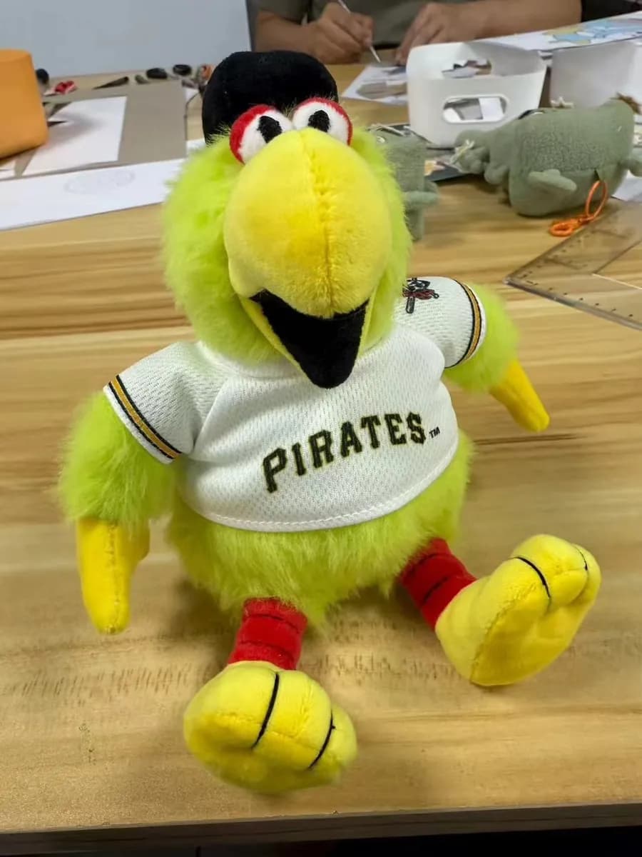 Parrot mascot plush in a baseball uniform with embroidered lettering